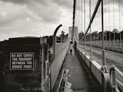 英格兰黑白风景的人行吊桥，捕捉了城市生活