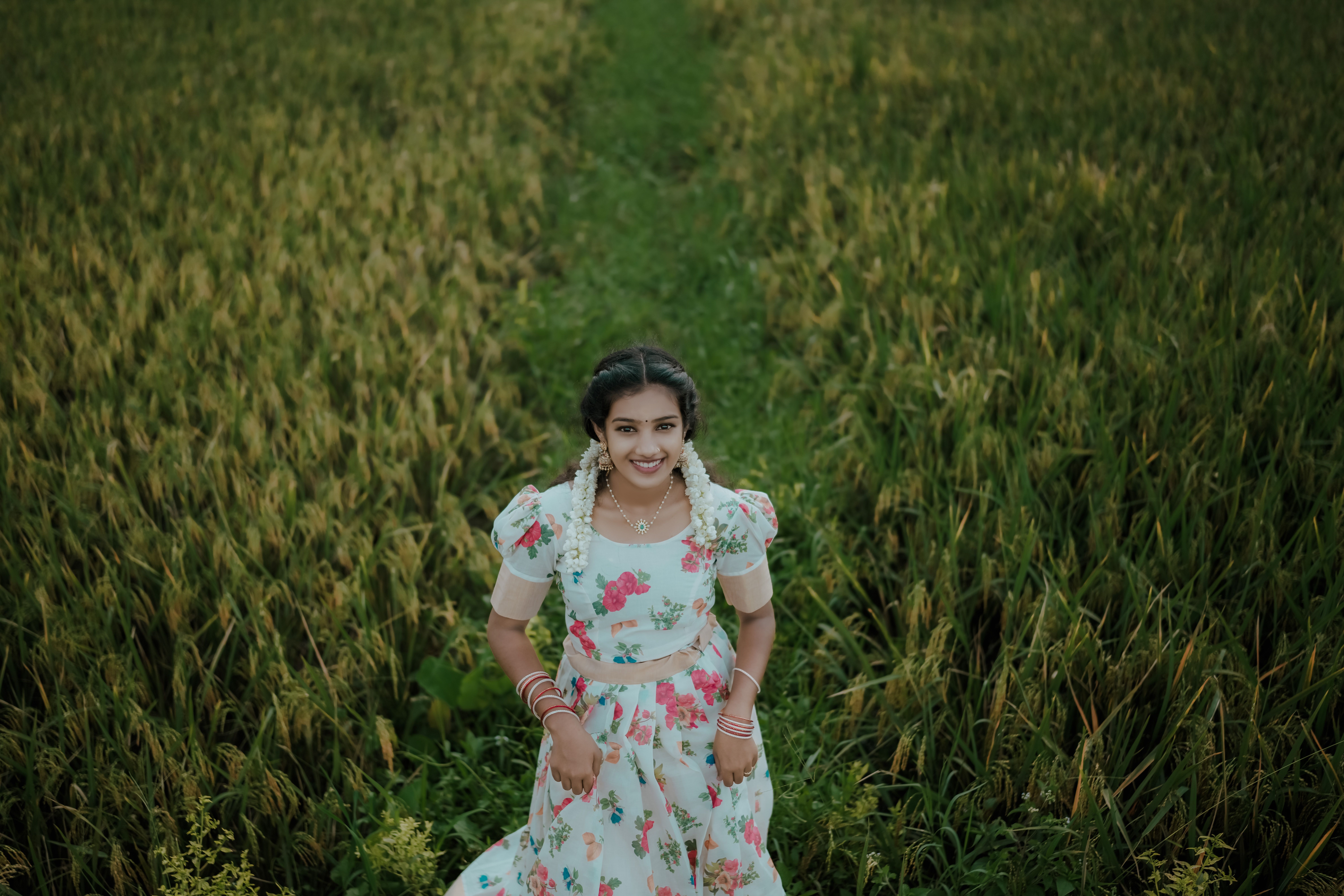 Young Woman in Floral Dress Smiling in Green Field · Free Stock Photo