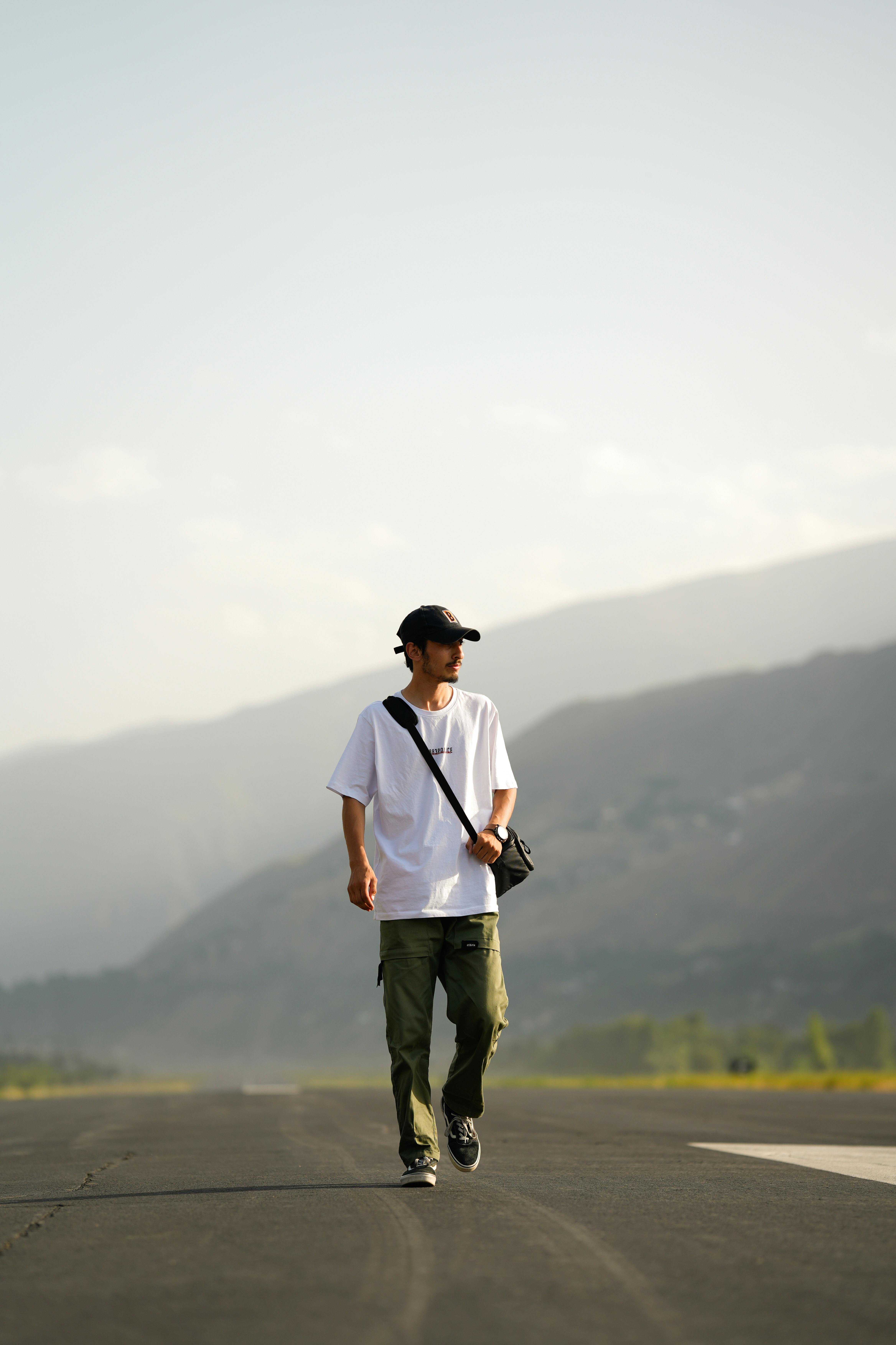 A man walks along a scenic mountain road in Chitral, Pakistan.