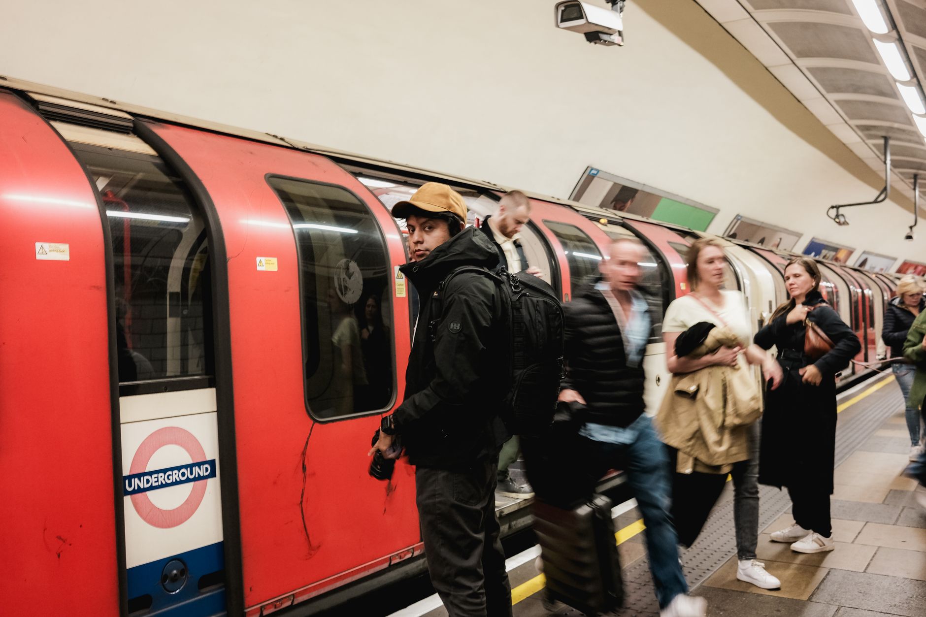 Travellers comparing London Underground routes with Arsenal and Chelsea match tickets at a railway station