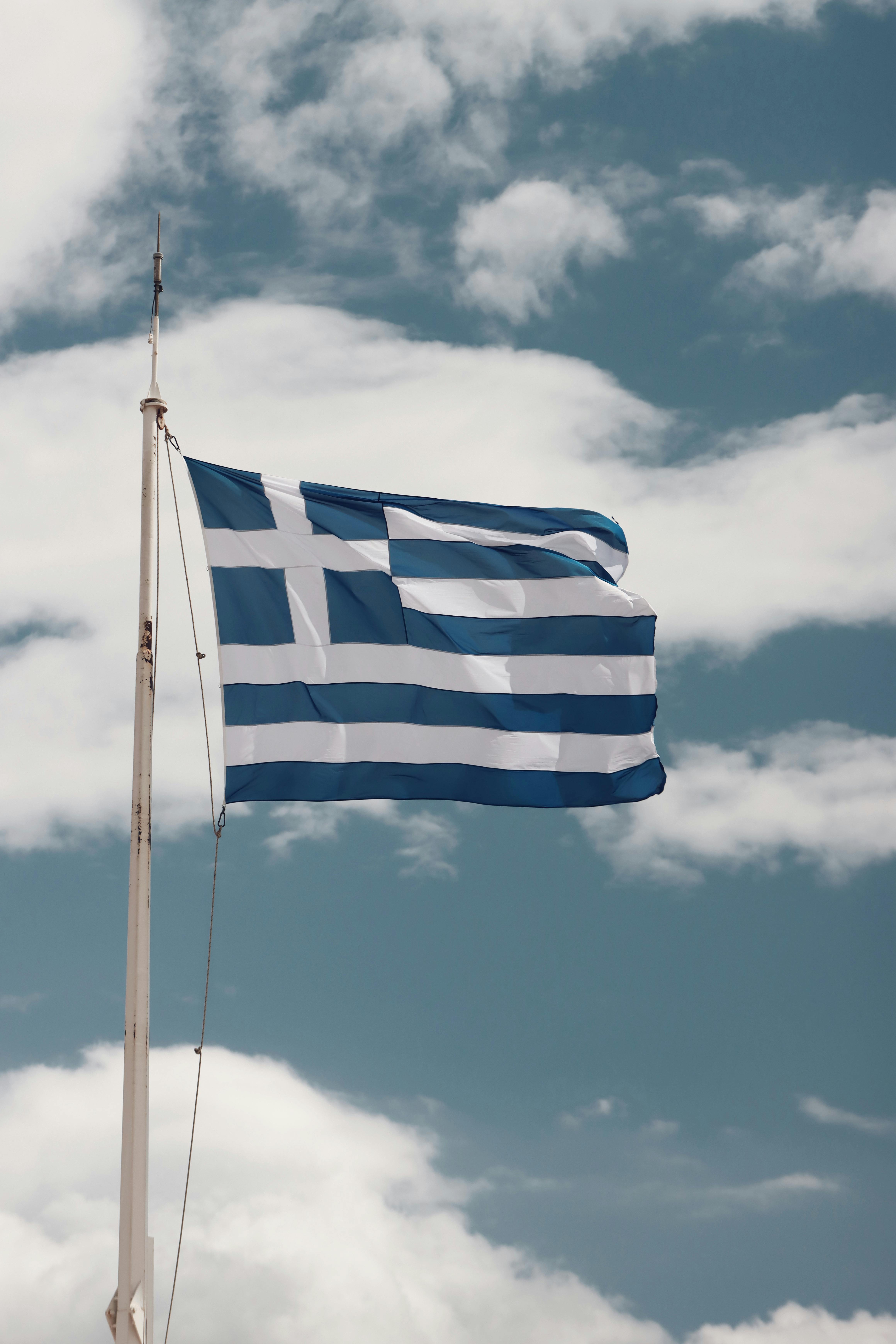 greek flag waving against a bright sky