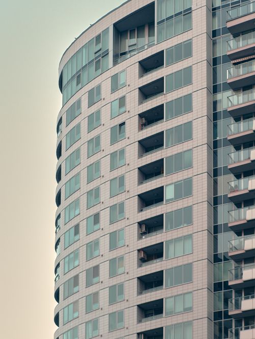 Free Curved facade of a modern apartment building showcasing urban architectural design. Stock Photo