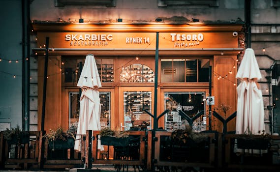 Warm, inviting exterior of Skarbiec restaurant with outdoor seating and lights.