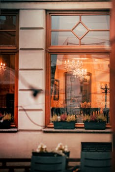 Elegant cafe window with view of chandelier-lit interior and warm decor.