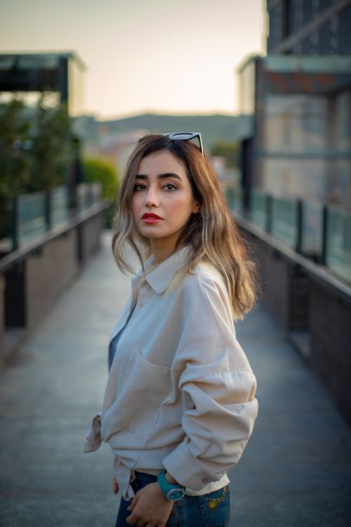 Free Fashionable woman with red lips posing confidently in outdoor setting. Stock Photo
