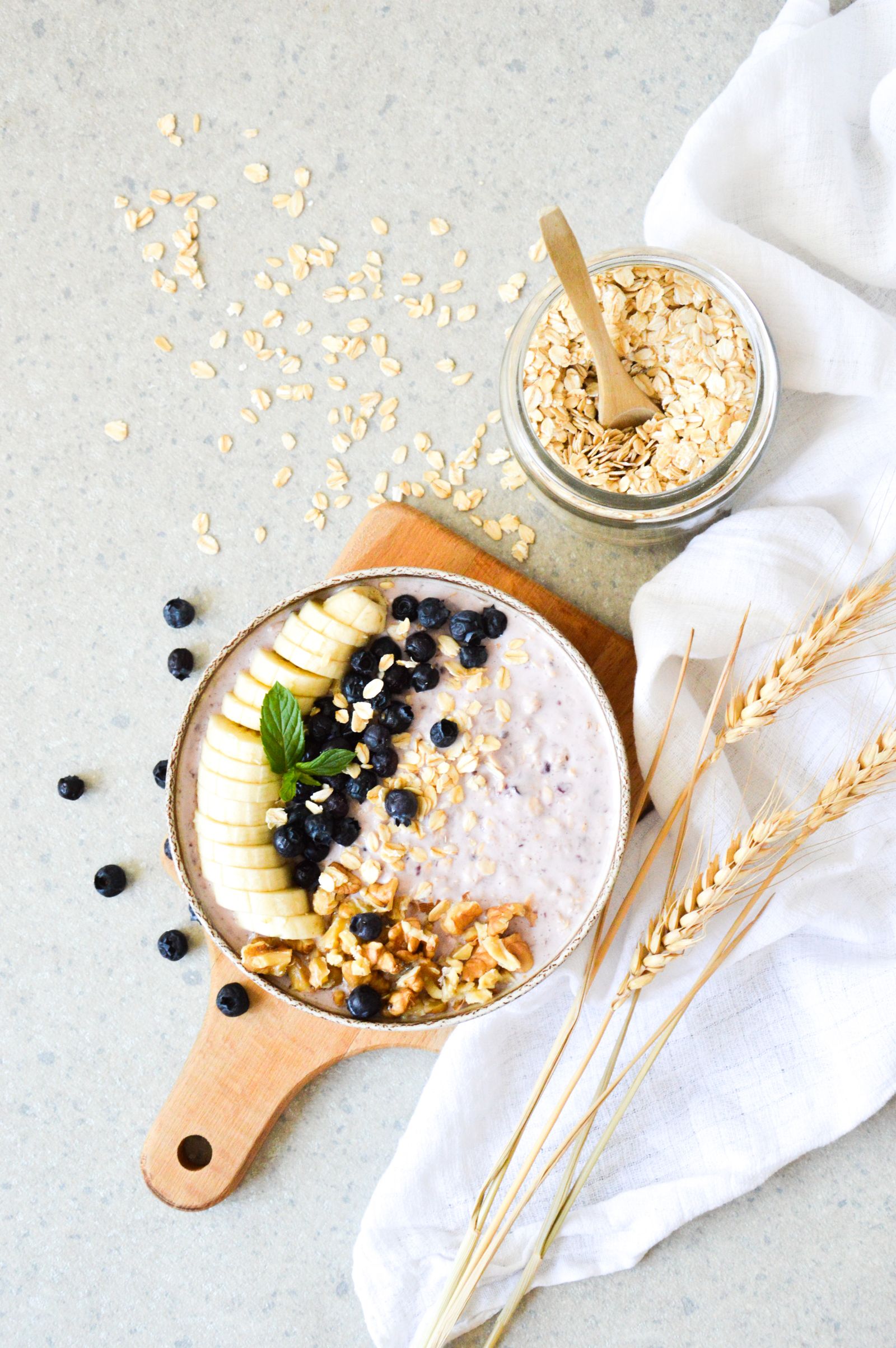A bowl of oats topped with blueberries, banana, and walnuts, a spread of prebiotic-fiber-rich foods that feed gut bacteria
