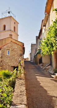 Charming view of a quaint street in Vinon-sur-Verdon, showcasing rustic stone buildings and sunny atmosphere. — photo by Pierre Bastien