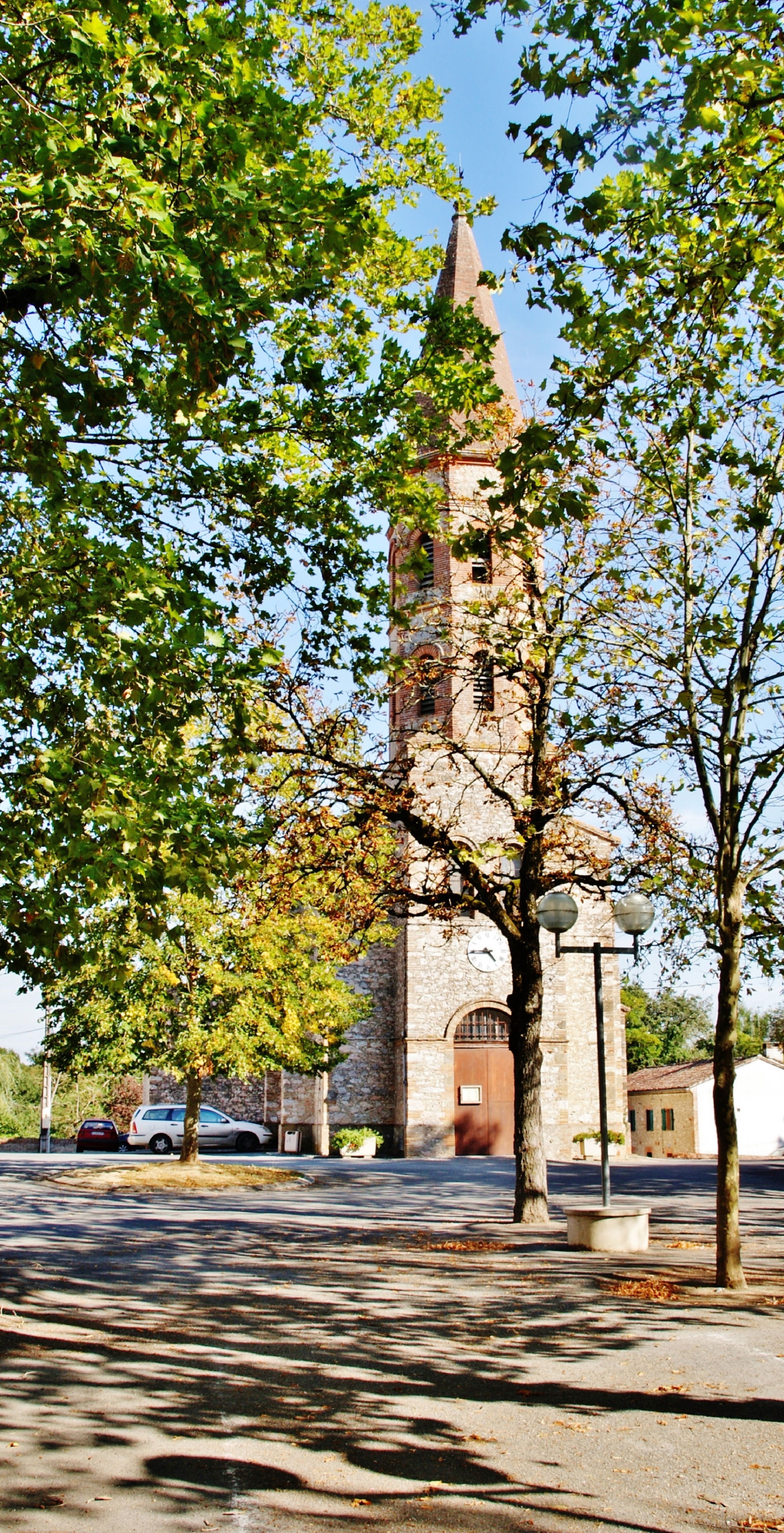 Scenic view of an ancient church in Viterbe, France surrounded by autumn trees.