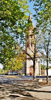 Scenic view of an ancient church in Viterbe, France surrounded by autumn trees.