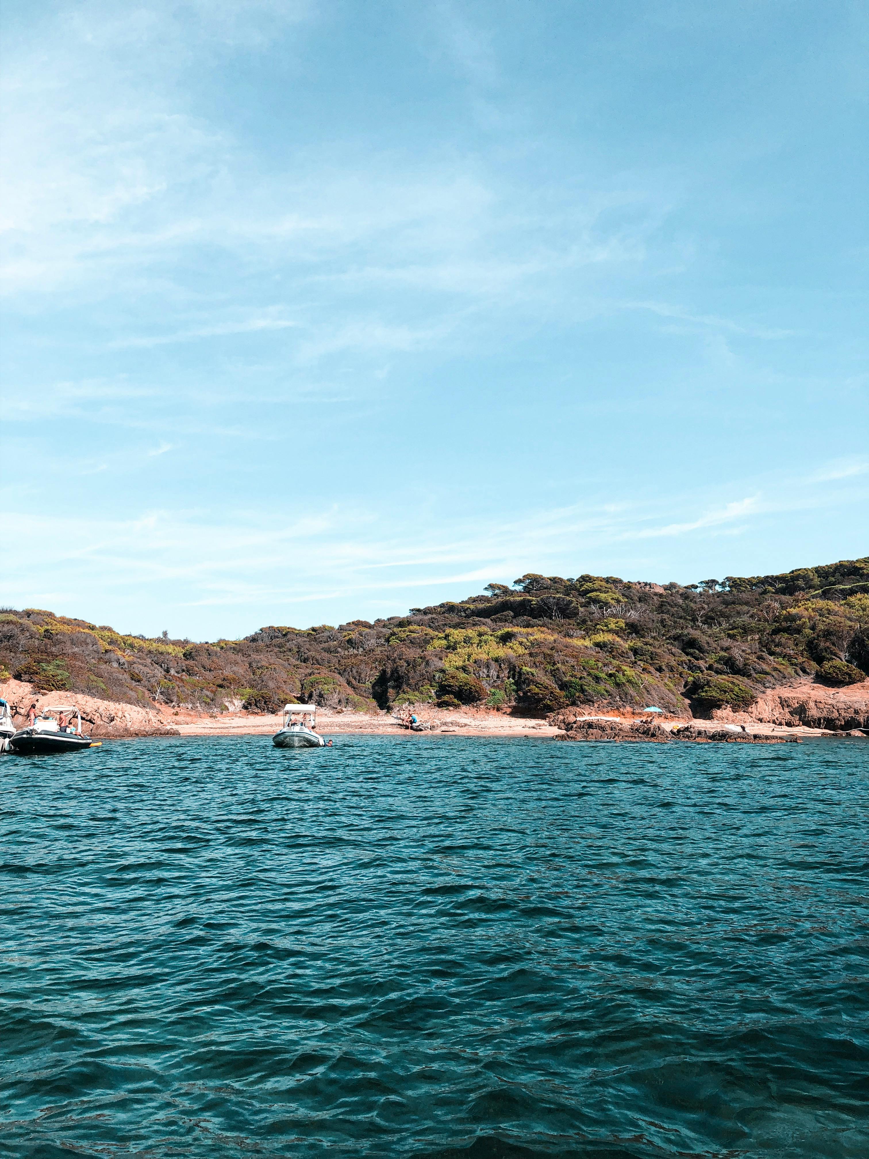 清澈的蓝色海水环绕着岩石岛，船只在其中穿行，这美丽的海景是完美的旅行灵感