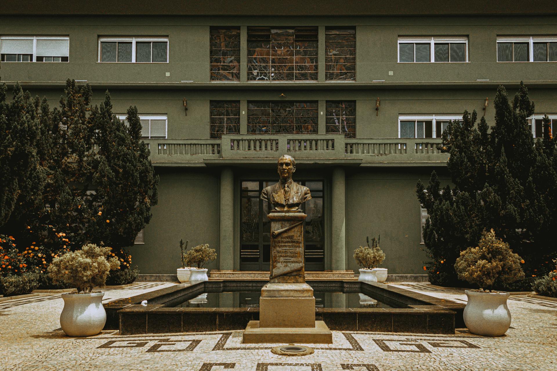 A bronze bust sculpture stands proudly before a government building facade in Goiânia, Brasil.