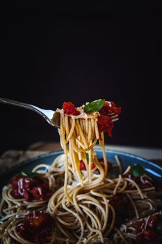 Close-up of spaghetti with tomato sauce, basil, and fork. Perfect for food lovers.