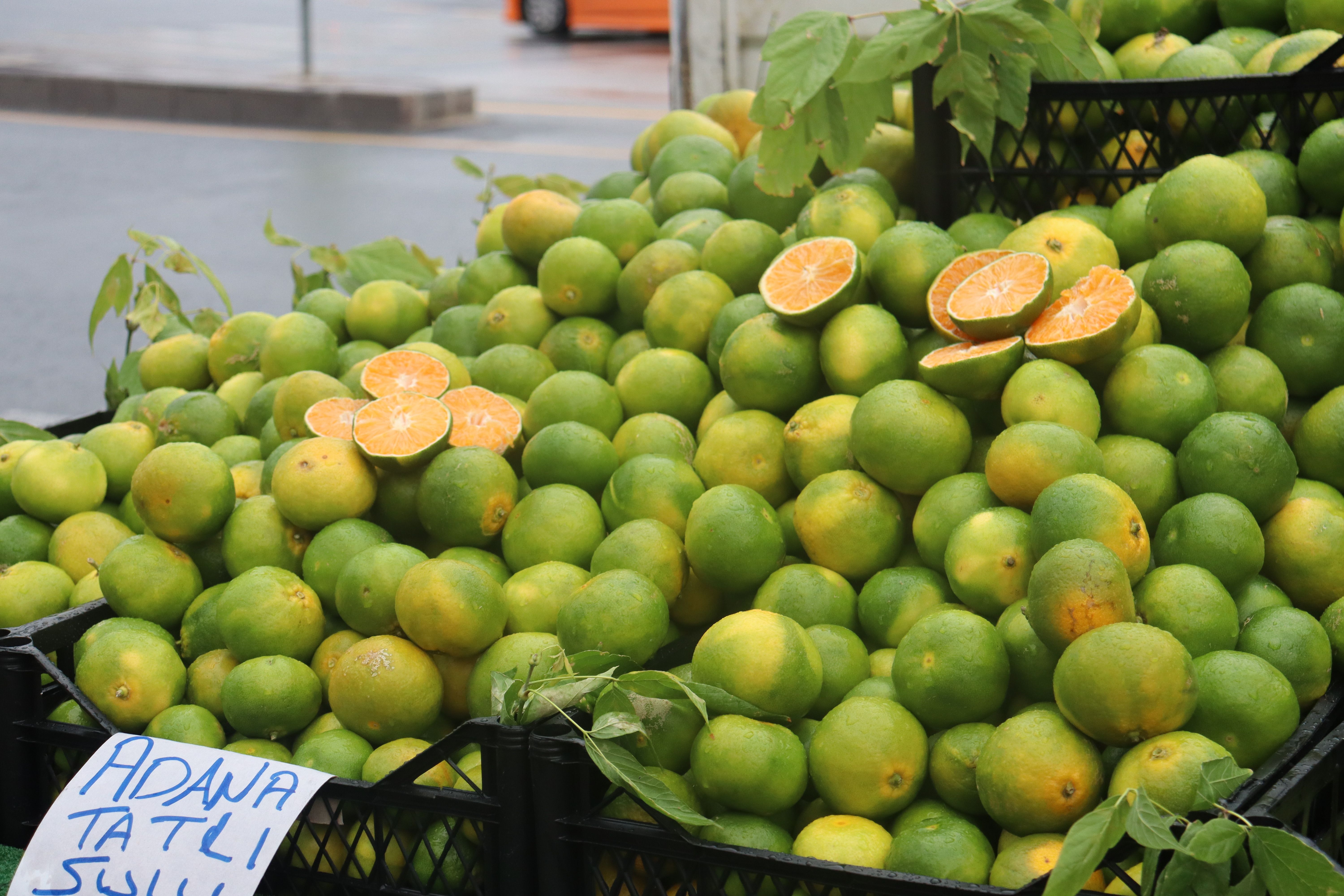 A vibrant display of fresh green tangerines at an outdoor market, showcasing vibrant citrus appeal.