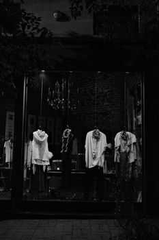 Elegant fashion store window display with black and white aesthetics at night.