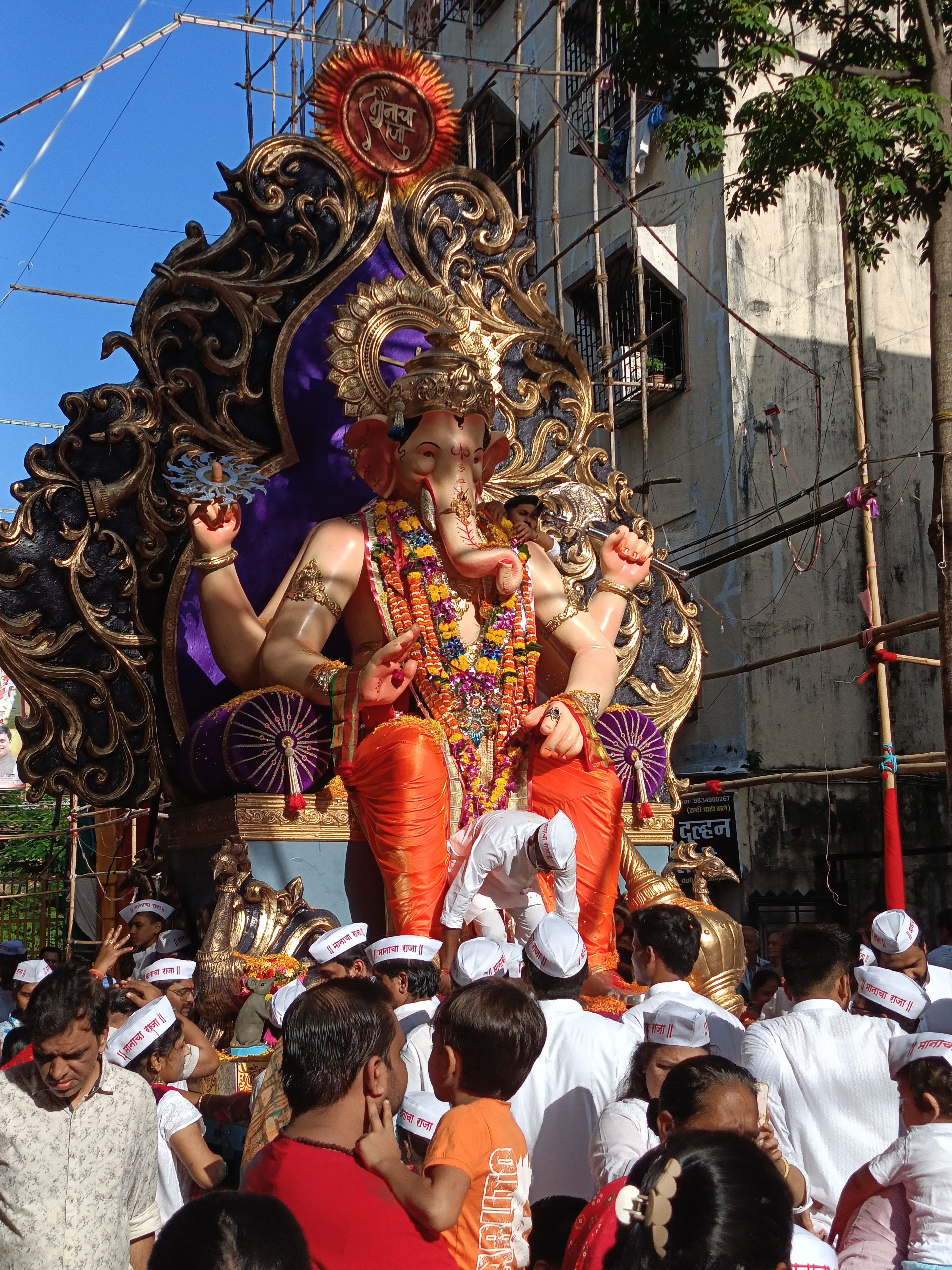 Devotees gather for Ganesh Chaturthi festival in Mumbai, showcasing vibrant colors and traditions.