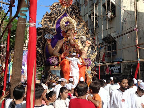 A colorful Ganesh Chaturthi procession captures the spirit of Mumbai with a large Ganesh idol surrounded by devotees.