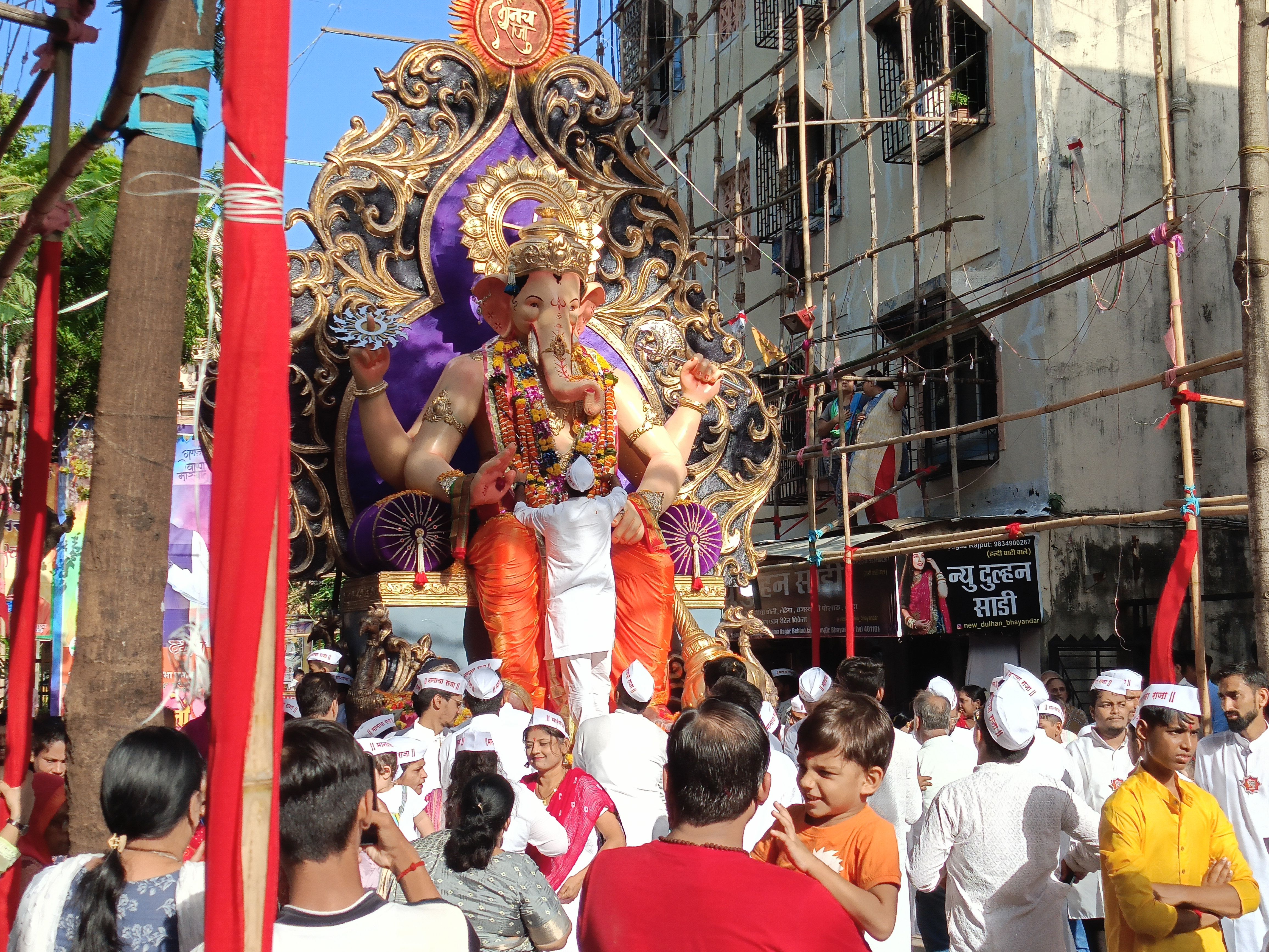 Devotees celebrating Ganesh Chaturthi with a grand procession in Mumbai's streets.
