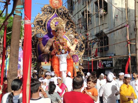 Devotees celebrating Ganesh Chaturthi with a grand procession in Mumbai's streets.