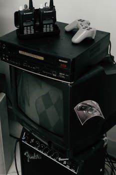 Vintage setup featuring old TV, walkie talkies, and gaming console, ideal for nostalgic themes.