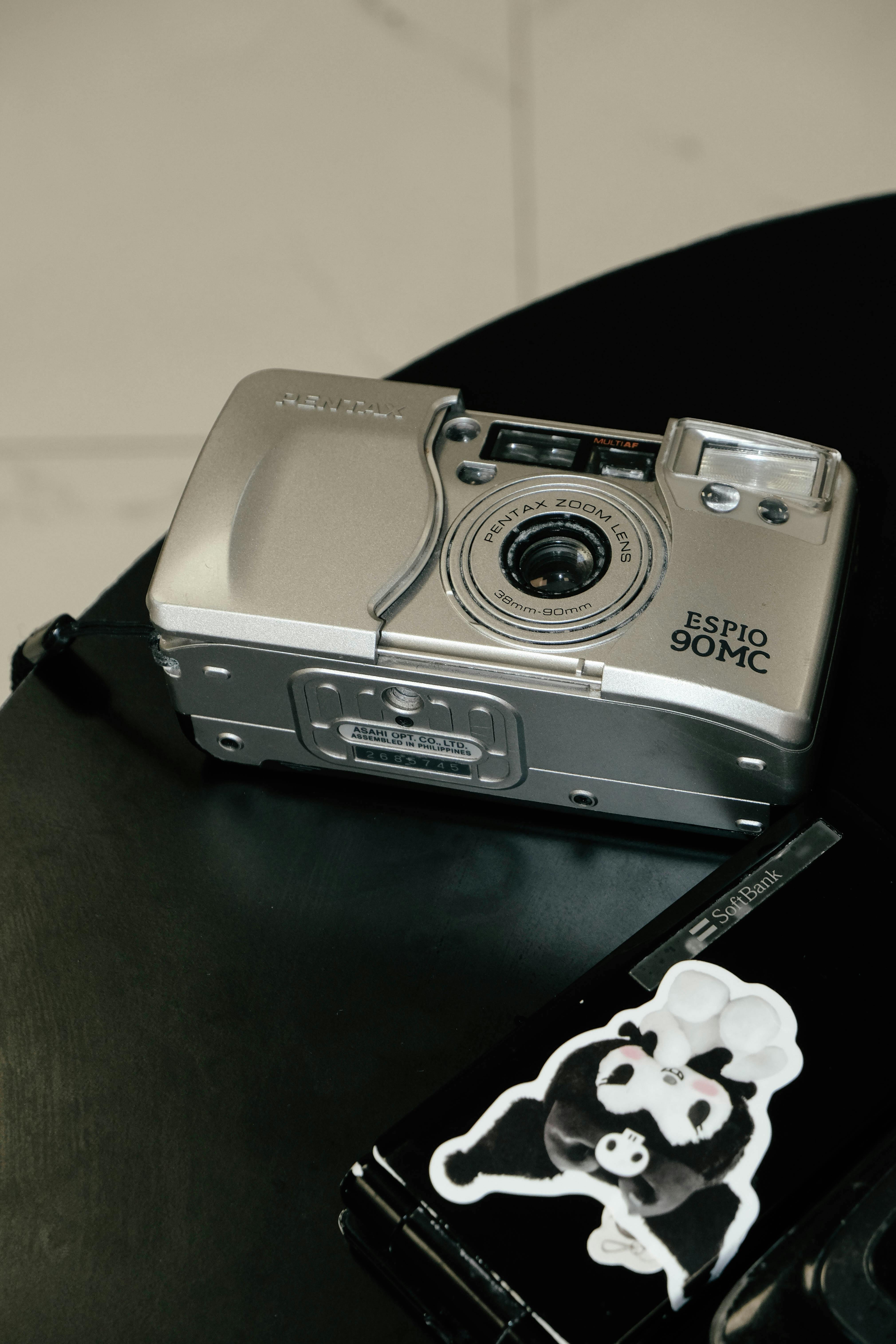 A silver vintage film camera on a stylish black table.