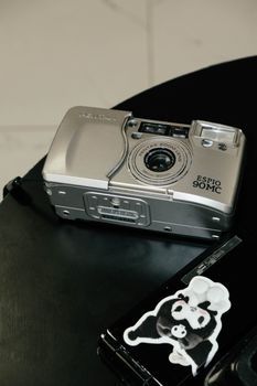 A silver vintage film camera on a stylish black table.