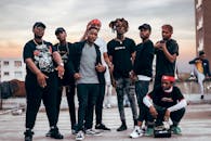 一群时尚的男人在德班的屋顶上，于日落时分自信地摆着姿势，尽显都市风尚