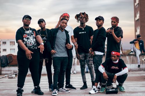 Free Stylish group of men posing confidently on a Durban rooftop during sunset. Fashionable urban vibe. Stock Photo