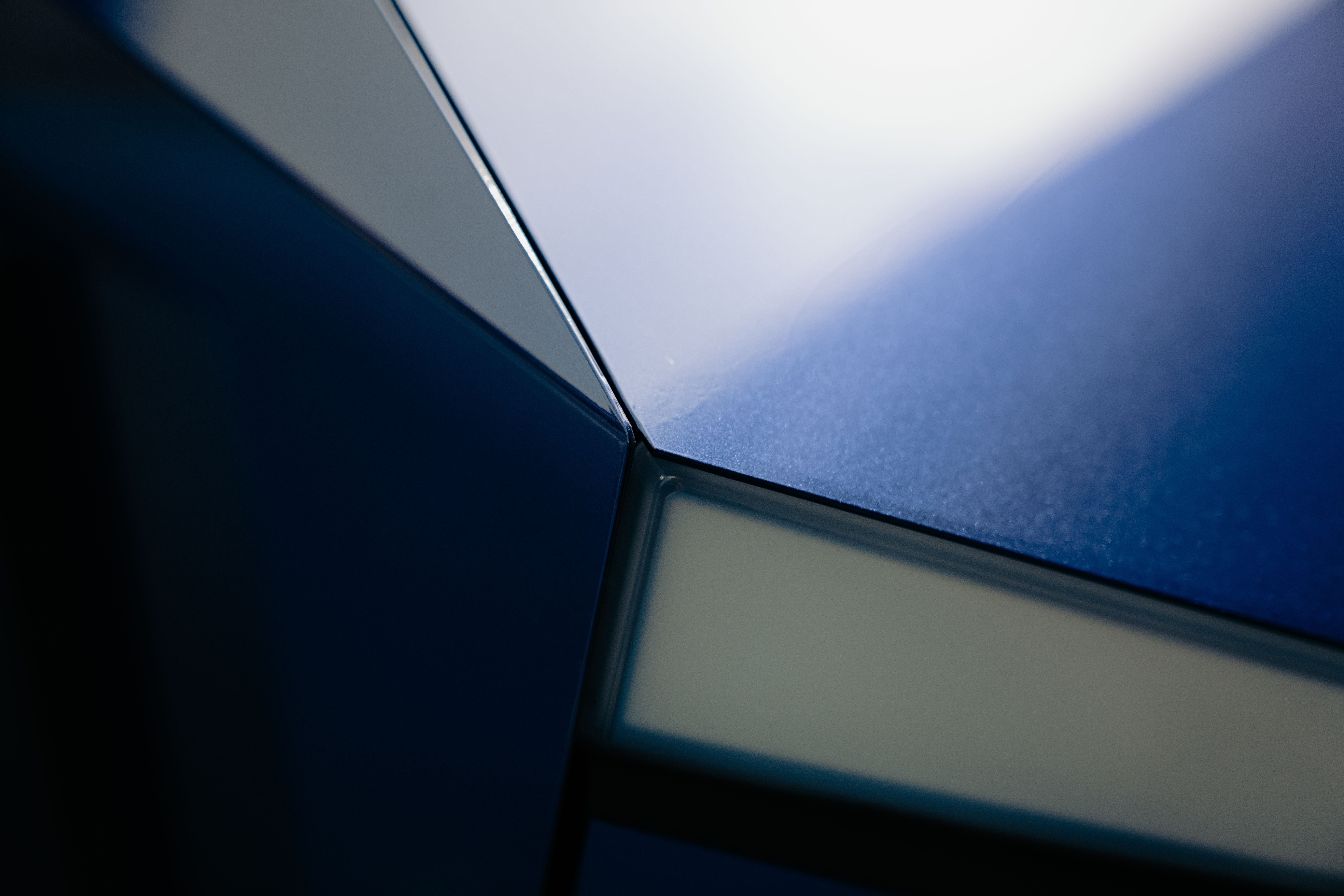 Abstract close-up of metallic surface with sleek geometric patterns and reflections.