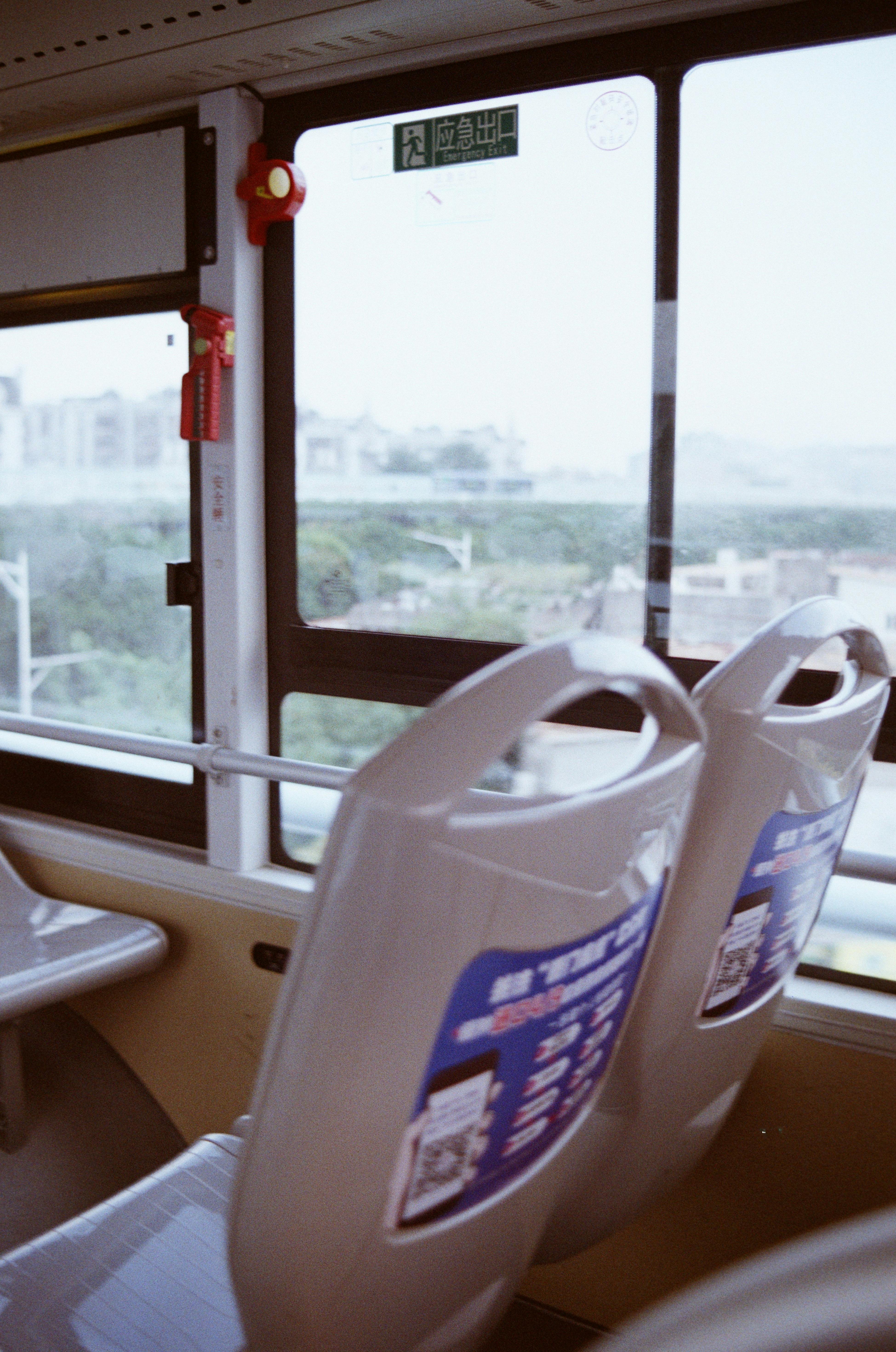 Free Photograph of an empty bus interior with a view of the cityscape outside through the window. Stock Photo