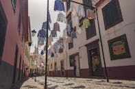 葡萄牙马德拉岛的一条迷人街道上，五颜六色的衣服在明亮的日光下挂着