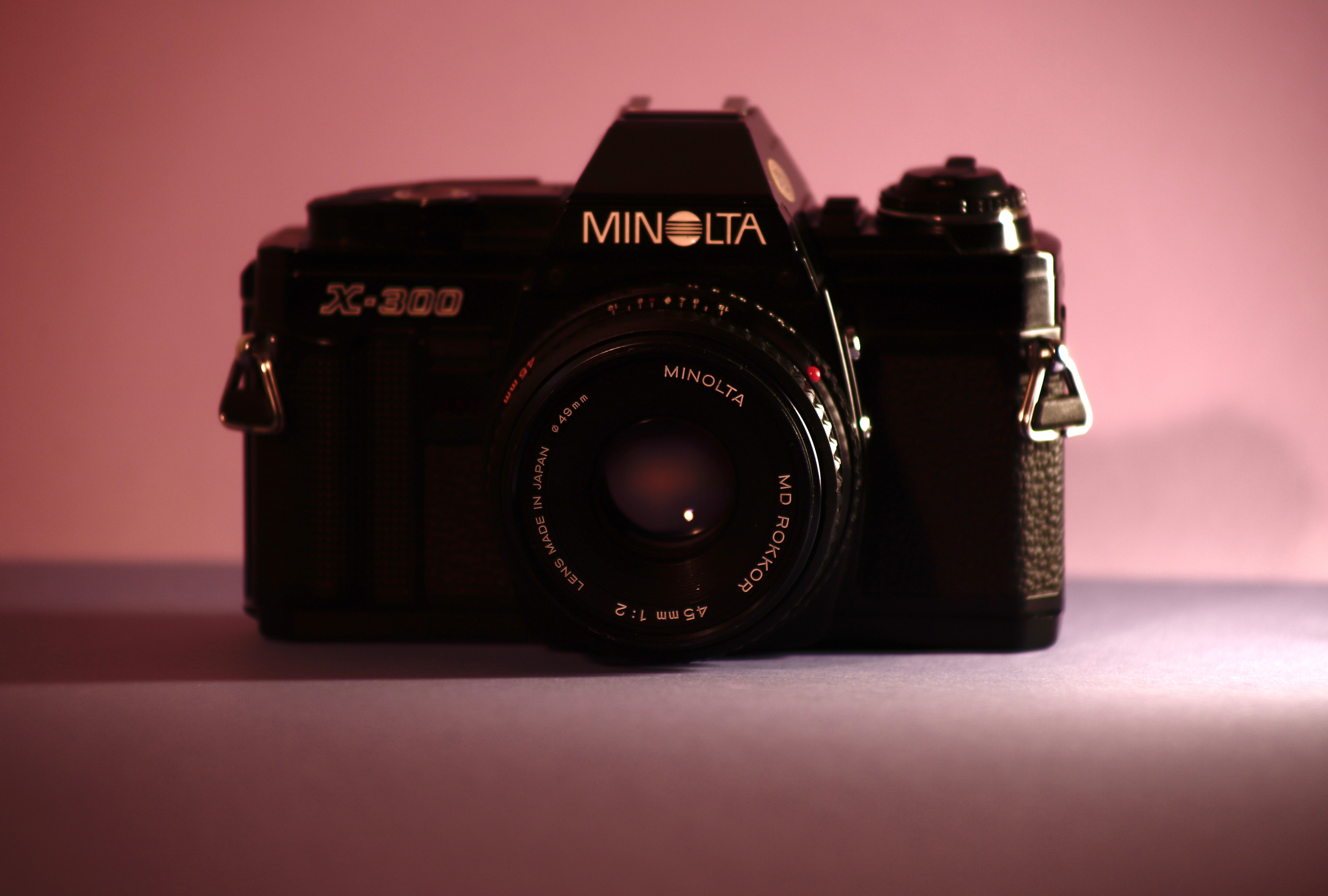 Retro Minolta X-300 camera placed on a colorful background, highlighting classic design.