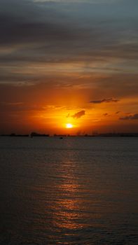 Beautiful sunset over the ocean with orange and blue tones reflecting on water.