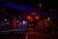 穆迪的夜间城市场景中，设有一座点亮的桥梁和带有交通信号灯的道路交叉口