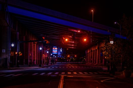 穆迪的夜间城市场景中，设有一座点亮的桥梁和带有交通信号灯的道路交叉口