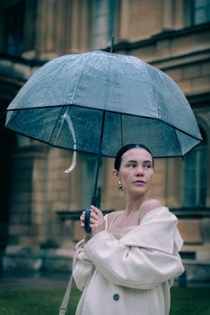 Stylish woman with a transparent umbrella outside a classic European building.