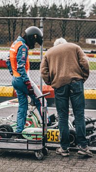 Driver and mechanic prepare a go-kart for a race at Berghem Circuit, Netherlands.