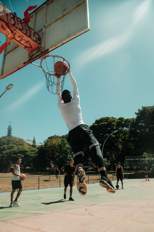 Free A thrilling basketball dunk captured in a sunny park in Brasília, Brazil. Stock Photo