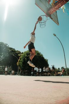 Dynamic action shot of a basketball player dunking outdoors in Brasília, Brasil.