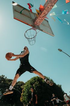 Basketball player performing a dunk outdoors in Brasília, Brazil.