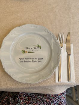 Charming table setup featuring a decorative plate with a Turkish inscription.