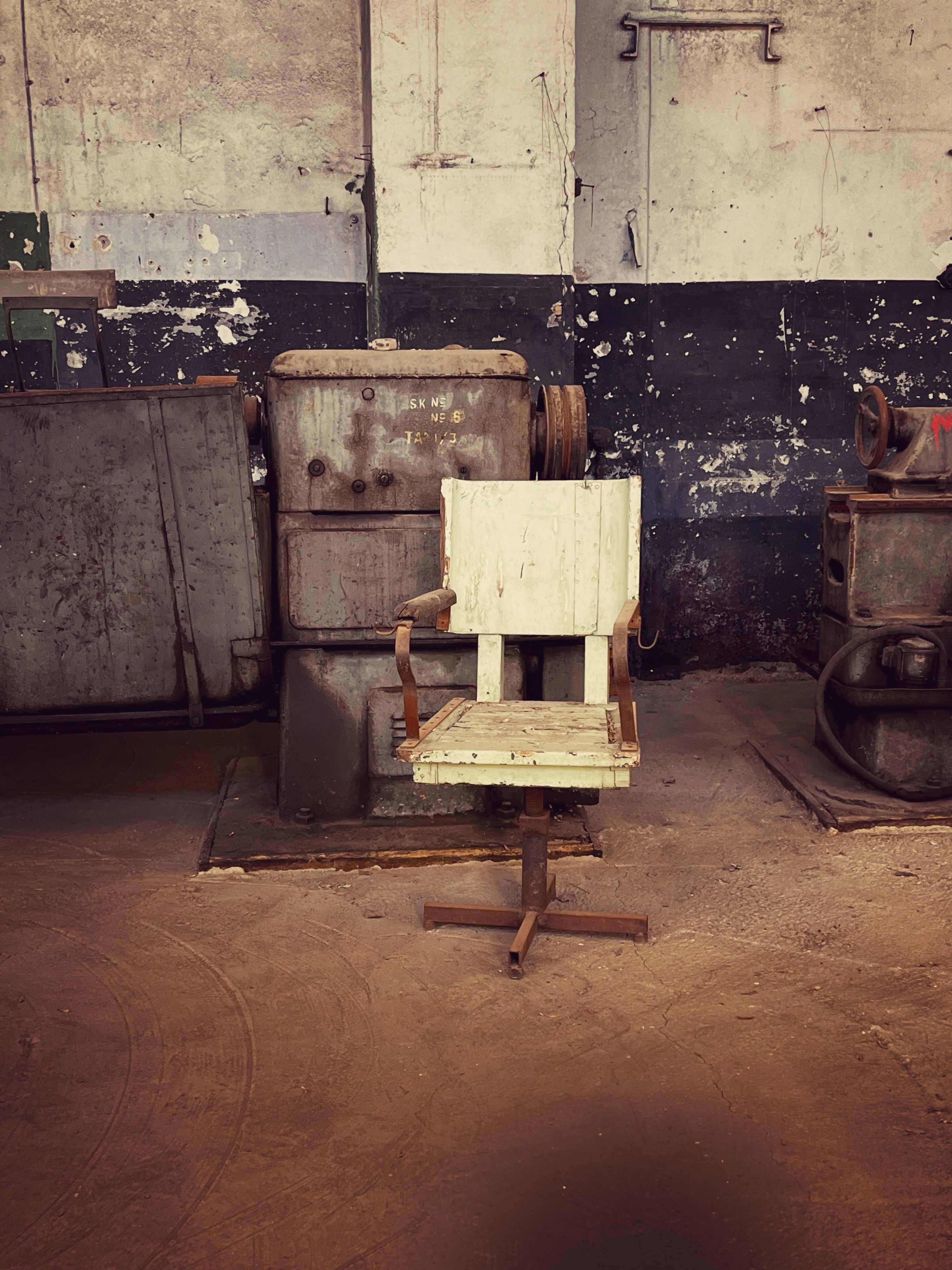 Old metal chair in a rustic abandoned factory setting.
