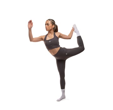 Fit young woman in activewear practicing a yoga pose in a studio setting. Ideal for fitness and wellness themes.