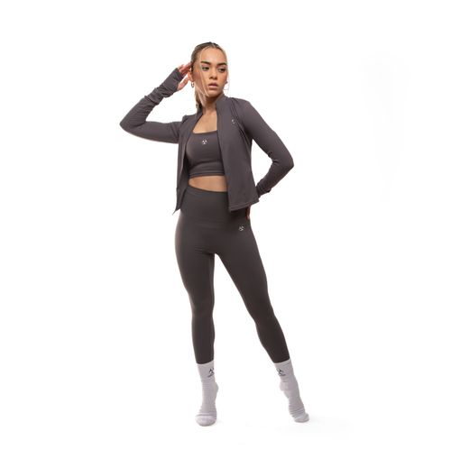 Free Woman in dark athletic wear striking a pose in a clean studio setting. Stock Photo