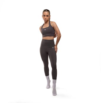 Confident woman in stylish sportswear posing in a bright studio setting. Perfect for fitness and fashion themes.