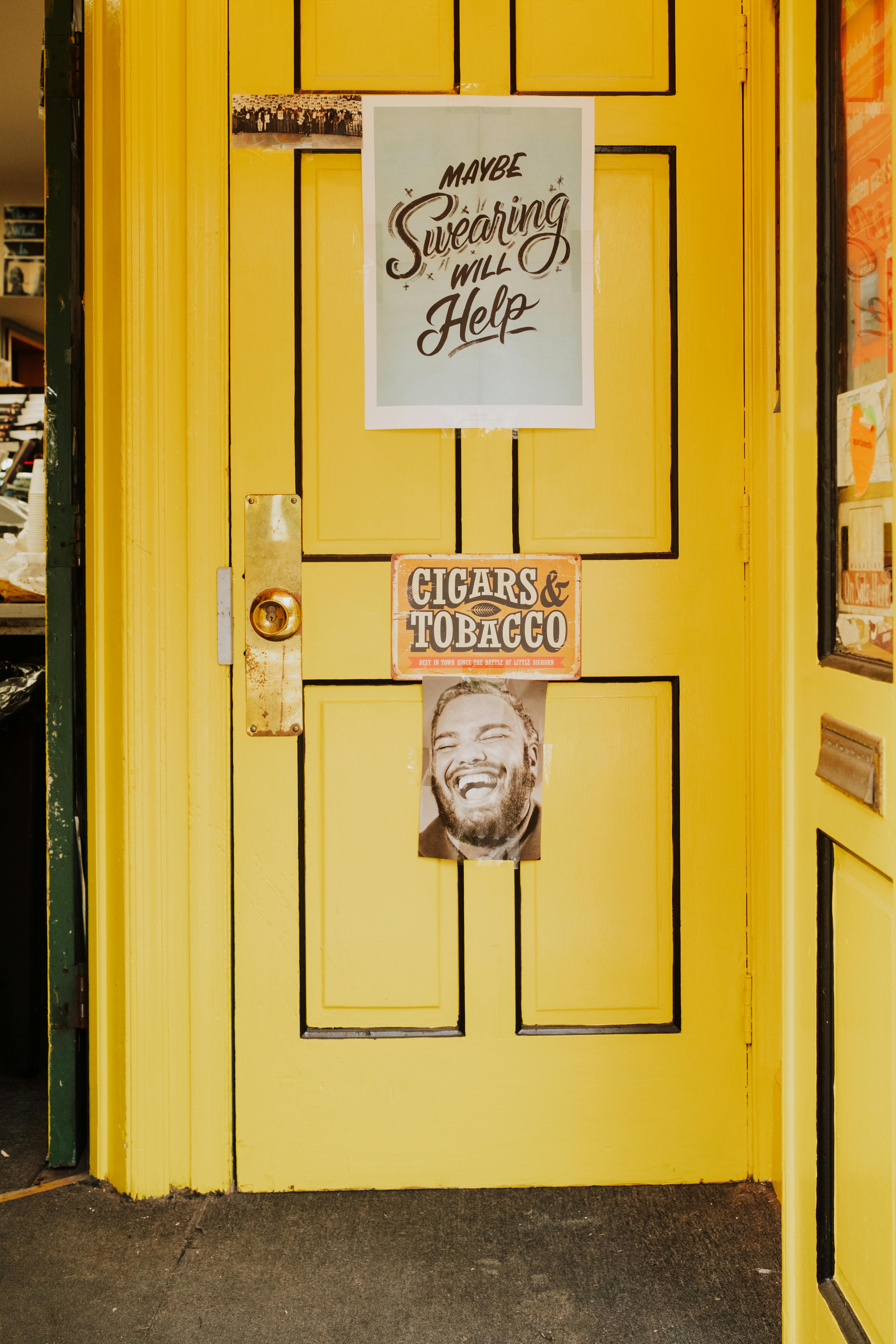 Vibrant yellow door with quirky signs in Philadelphia, capturing urban charm.