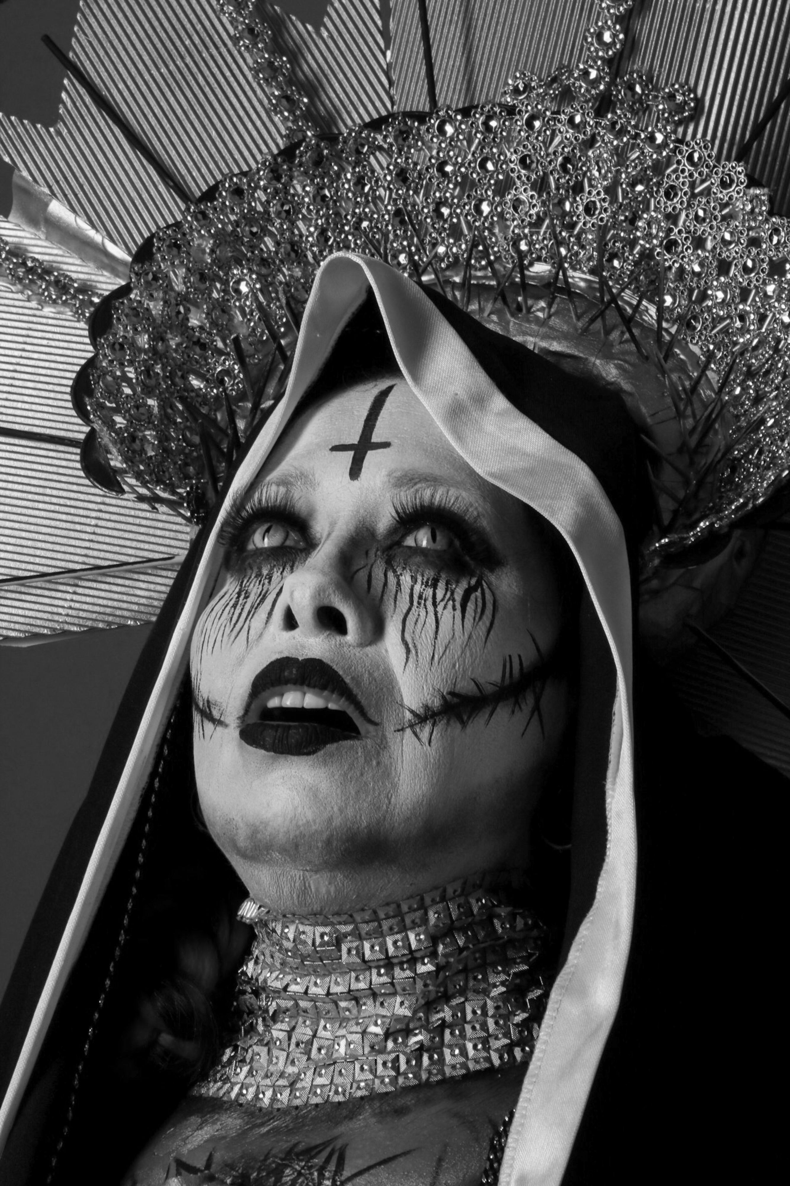 Gothic-style portrait of a person in elaborate headdress with dramatic makeup.