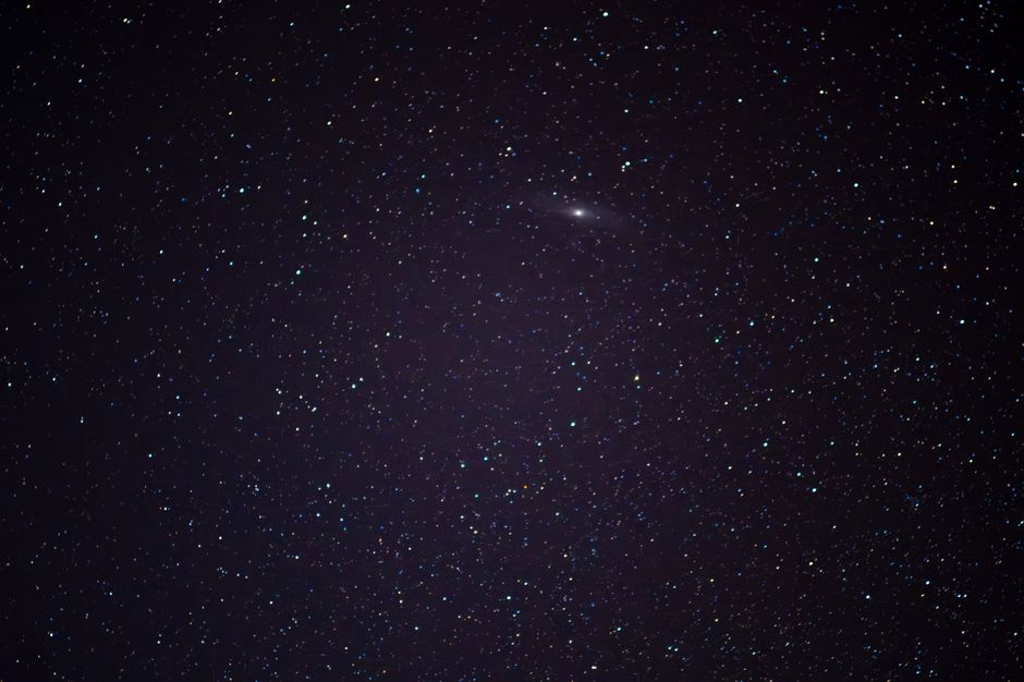Fotomural Una vista hipnotizante del cielo nocturno lleno de estrellas que presenta la Galaxia de Andrómeda.