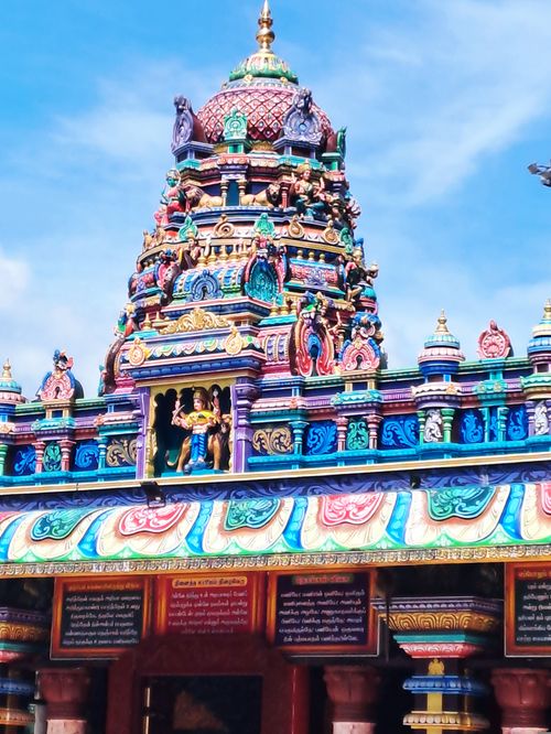 Free Colorful and detailed gopuram of a South Indian temple under a clear blue sky. Stock Photo