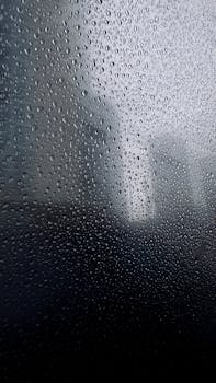 Raindrops pattern on glass with Toronto cityscape in the background during fall.