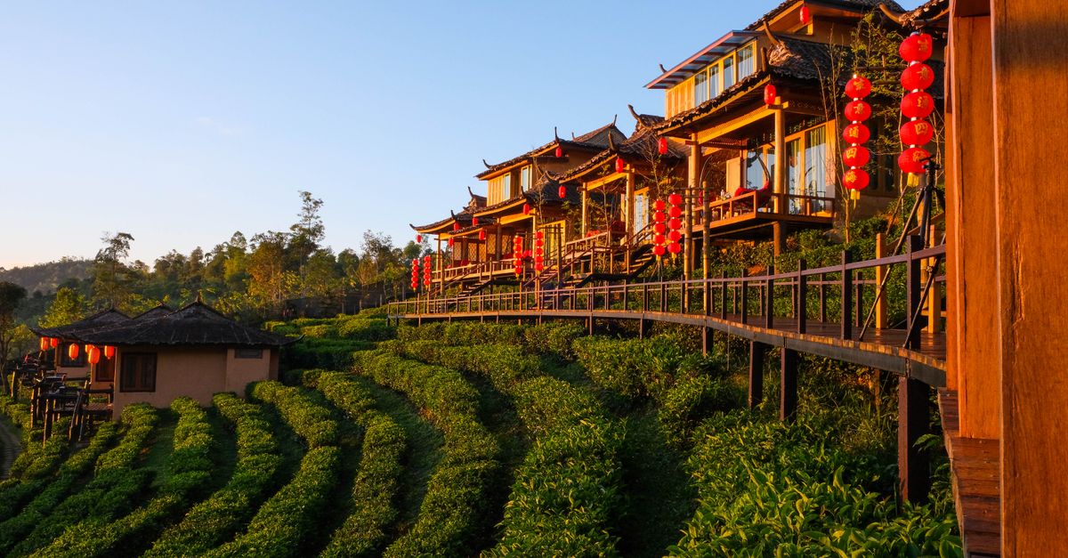 Stunning view of traditional Thai architecture with vibrant red lanterns during sunrise in Chiang Mai, Thailand.